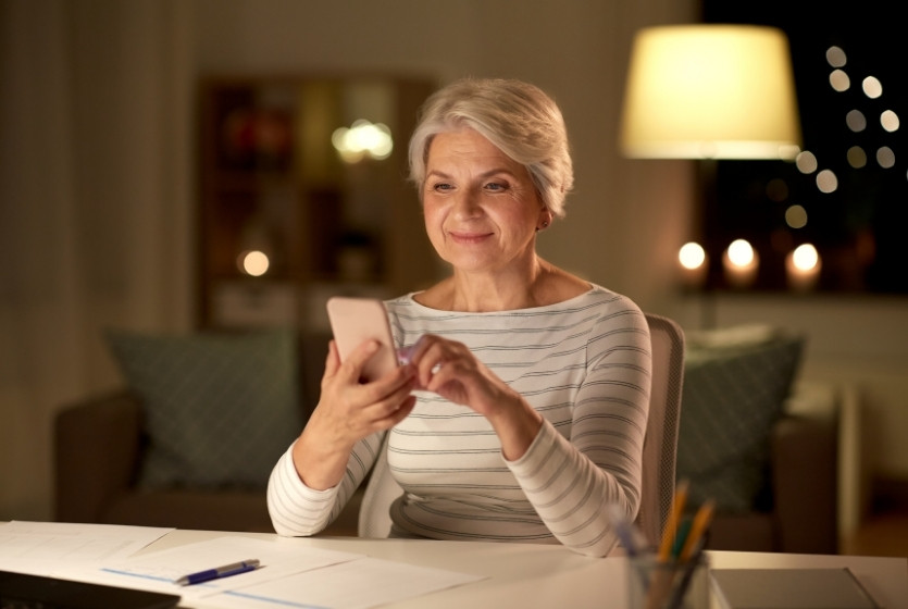 A woman using the MowSnowPros mobile app on a smartphone device